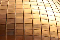 A curved, gridlike metallic structure with the sun shining on it