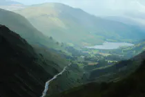 A verdant valley with a river leading to a lake