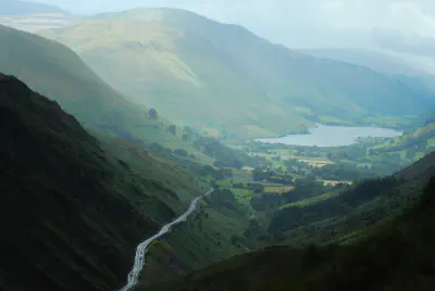 A verdant valley with a river leading to a lake