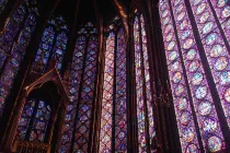 A tall wall of stained glass windows inside a church