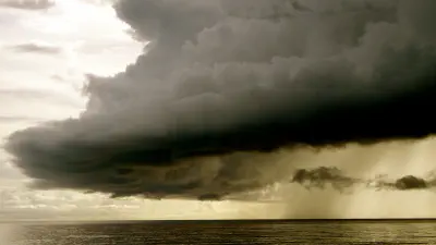 A dark, ominous storm cloud above water